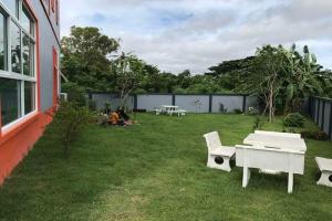 a group of people sitting on the grass in a yard at The Hope Apartment in Ban Chang