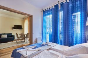 1 dormitorio con 1 cama con cortinas azules en Baltycka 10 by Baltic Home, en Świnoujście