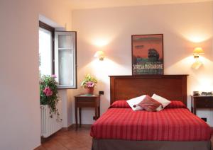 um quarto com uma cama com uma colcha vermelha em Hotel La Locanda em Stresa