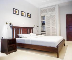 a bedroom with a large bed with a wooden frame at Riad Prince Louis in Yaoundé