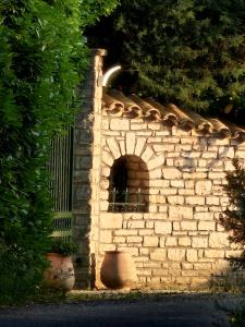 een stenen muur met een klein raam erin bij La Vigne Blanche Gîtes in Lamotte-du-Rhône