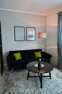 a living room with a black couch and a table at Modernes Apt mit direkter Anbindung zur City und Messe in Hannover