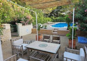 een patio met een tafel en stoelen en een zwembad bij La Vigne Blanche Gîtes in Lamotte-du-Rhône
