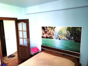 1 dormitorio con una gran pintura en la pared en Venus Plaza Apartment Ploiesti, en Ploieşti
