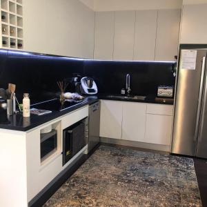 eine Küche mit weißen Schränken und einem Edelstahlkühlschrank in der Unterkunft Kookaburra Cottage in Bowral + 11 Fotos