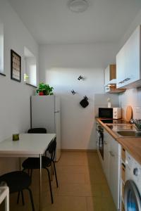 Una cocina con una mesa y un refrigerador blanco. en Modernes Apt mit direkter Anbindung zur City und Messe, en Hannover