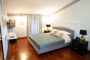 een slaapkamer met een bed en een bureau met een lamp bij Relais Santa Caterina Hotel in Viterbo