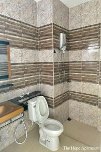 a bathroom with a toilet and a shower at The Hope Apartment in Ban Chang