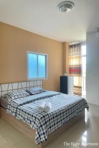 een slaapkamer met een bed met twee handdoeken erop bij The Hope Apartment in Ban Chang