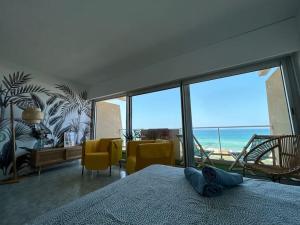 a bedroom with a bed and a view of the ocean at Splendide vue à 180 sur l’océan in Lacanau