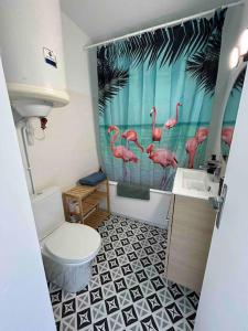 ein Badezimmer mit rosa Flamingos auf dem Duschvorhang in der Unterkunft Splendide vue à 180 sur l’océan in Lacanau