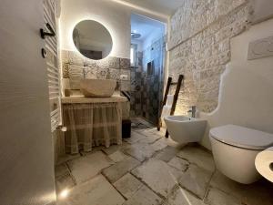 a bathroom with two sinks and a toilet and a mirror at SUITE - Trullo Relax sul Monte in Cisternino +29 photos
