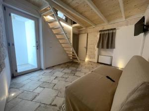 a living room with a couch and a staircase at SUITE - Trullo Relax sul Monte in Cisternino