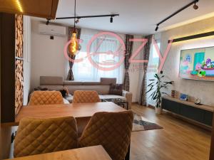 a living room with a table and a couch at Apartman -Cozy Lake- Sarajevo in Lukavica