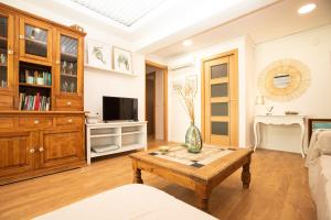 a living room with a coffee table and a tv at Apartamento La Luz by Clabao in Denia