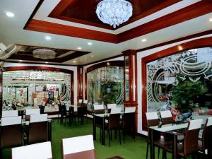 un restaurante con mesas y sillas y una lámpara de araña en Marine paradise Encore, en Pattaya South
