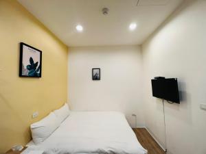 a bedroom with a bed and a flat screen tv at 淡水民宿-台北Yes Hotel in Tamsui