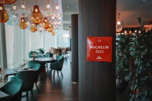 um sinal num poste num restaurante com mesas e cadeiras em Hilton Rijeka Costabella Beach Resort And Spa em Rijeka