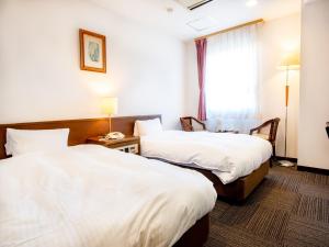 a hotel room with two beds and a window at 小牧シティホテル in Komaki +28 photos