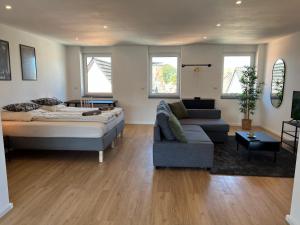 a living room with a bed and a couch at ZENITH STAY - hochwertige Apartments direkt in der Innenstadt in Erkelenz