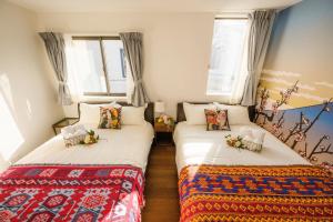 two twin beds in a room with windows at Tokyo Private villa/near station/Ginza/Asakusa/Sky Tree/Louis House in Tokyo