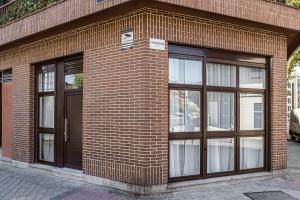 a brick building with three windows and a door at Exyca Embajadores in Madrid