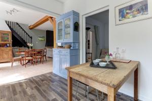 cocina y comedor con armarios azules y mesa en Villa Jeannot - Maison avec jardin, en Laon