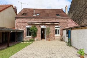 una casa de ladrillo con una entrada delante de ella en Villa Jeannot - Maison avec jardin en Laon