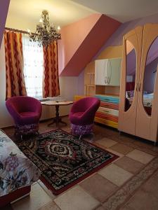 a bedroom with purple chairs and a table and a bed at Flamingo 