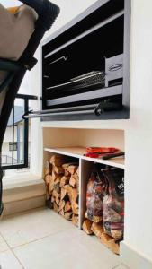 a tv sitting on top of a shelf with fire wood at BALLITO HILLS , 2 bedroom apartment in Ballito