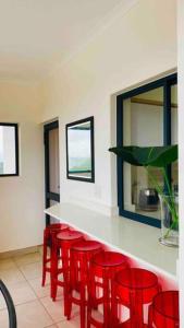 a kitchen with red chairs and a white counter at BALLITO HILLS , 2 bedroom apartment in Ballito