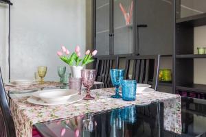 A casa di Elga في تيرمولي: طاولة عليها صحون و كاسات و ورد