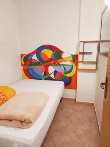 Habitación con cama y pintura en la pared en Sguardo nel bosco - Appartamento - Terminillo, en Terminillo