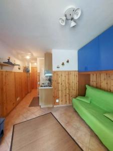 テルミニッロにあるSguardo nel bosco - Appartamento - Terminilloのリビングルーム(緑のソファ付)、キッチンが備わります。