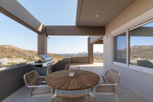 a balcony with a table and chairs and a grill at Marsane Luxury Appartments in Faliraki