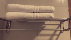 drie handdoeken op een handdoekenrek in de badkamer bij Unique Home in Yanbu