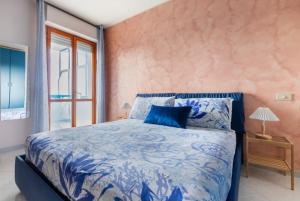 A casa di Elga في تيرمولي: غرفة نوم بسرير ازرق ونافذة