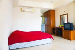 1 dormitorio con cama roja y TV en สงค์ศักดิ์พะเยา, en Phayao