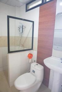 La salle de bains est pourvue de toilettes blanches et d'un lavabo. dans l'établissement สงค์ศักดิ์พะเยา, à Phayao