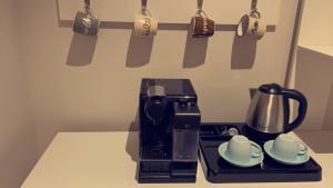 a coffee maker sitting on a counter with two cups at Unique Home in Yanbu