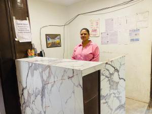 a woman standing behind a counter in a room at Qotel Hotel Pitampura Couple Friendly in New Delhi