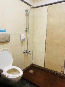 a bathroom with a toilet and a shower stall at Qotel Hotel Pitampura Couple Friendly in New Delhi