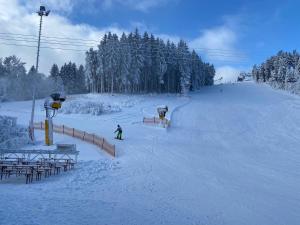 a person is skiing down a snow covered slope at VIP Haus Winterberg in Winterberg