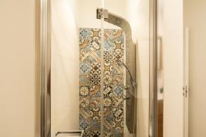 La salle de bains est pourvue d'une douche et d'un mur en mosaïque. dans l'établissement Appartamento Adara by Wonderful Italy, à Bari