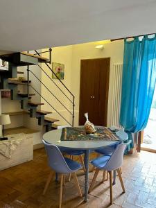 a dining room with a table and chairs and a staircase at Wine & Roses in Mattinata