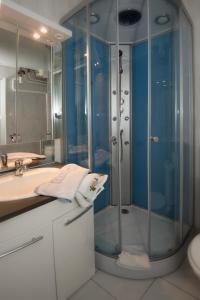 a bathroom with a glass shower and a sink at Résidence Plaisance in Gérardmer