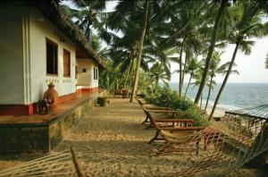 un porche de un edificio junto al océano en Karikkathi Beach Villa rooms en Thiruvananthapuram