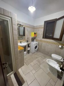 a bathroom with a sink and a washing machine at Dimora Storica San Giovanni in Zollino