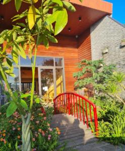 a red bench in front of a house at An Nhiên Villa in Bao Loc