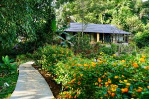 a garden path leading to a house with flowers at Moc Chau Retreat in Mộc Châu